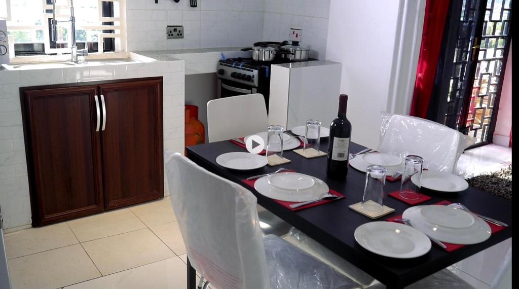 Dining table laid with glassware and wine beside the kitchen