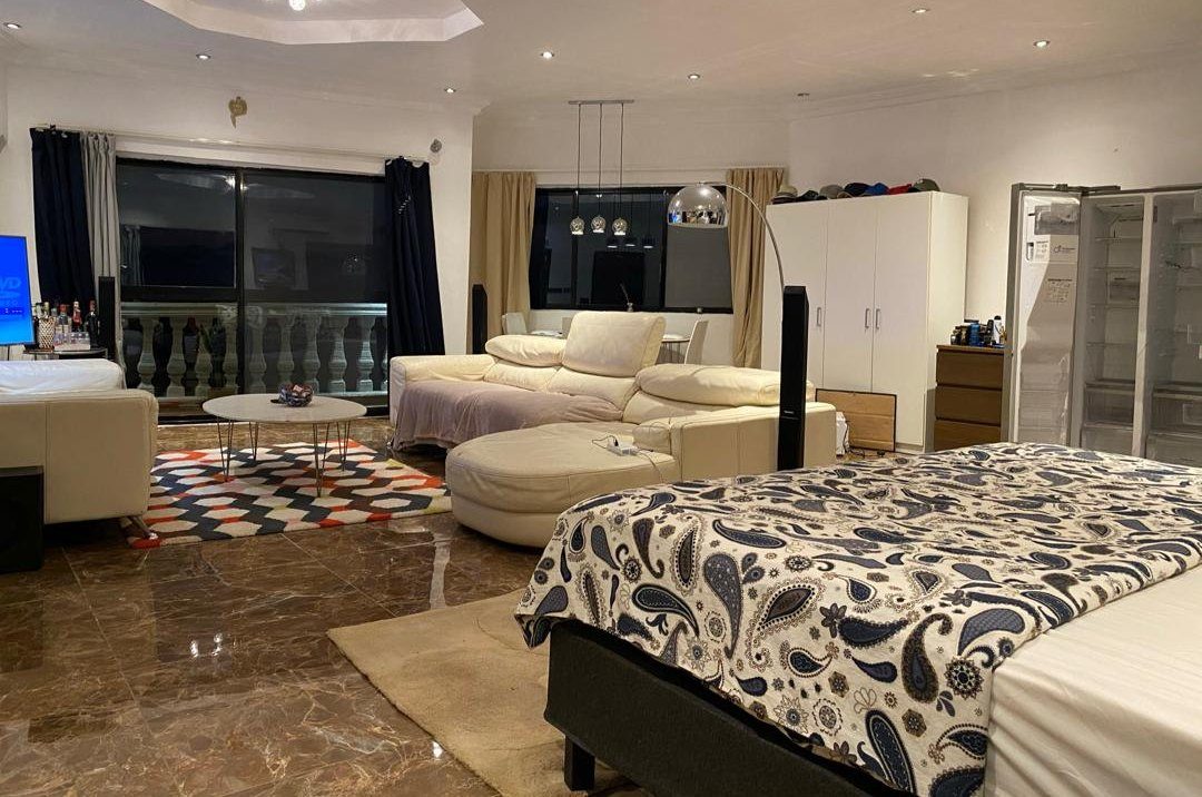 Studio penthouse open-plan living area with seating, bed and balcony