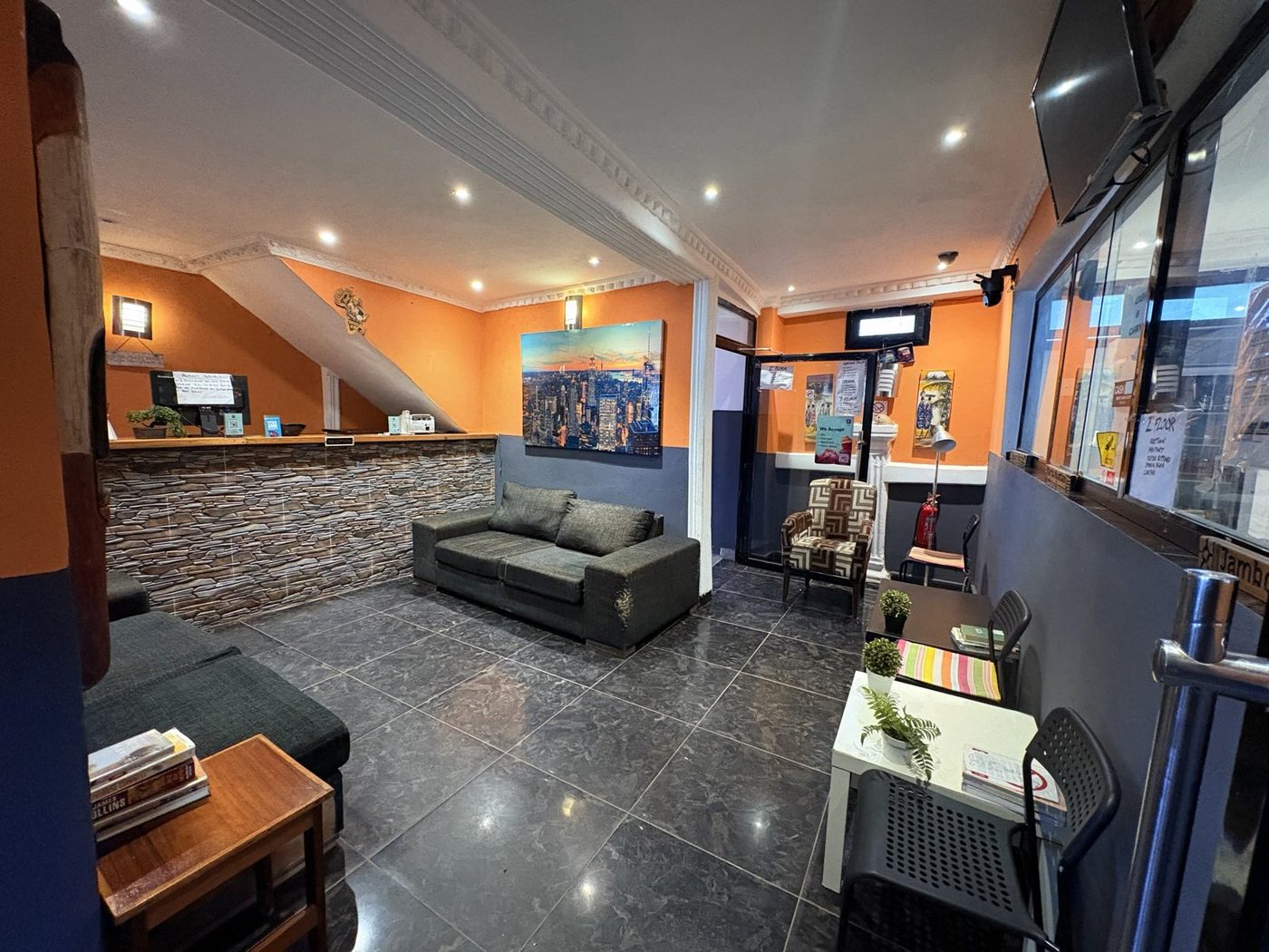 Belvoir reception and lounge with warm orange walls and stone accent desk