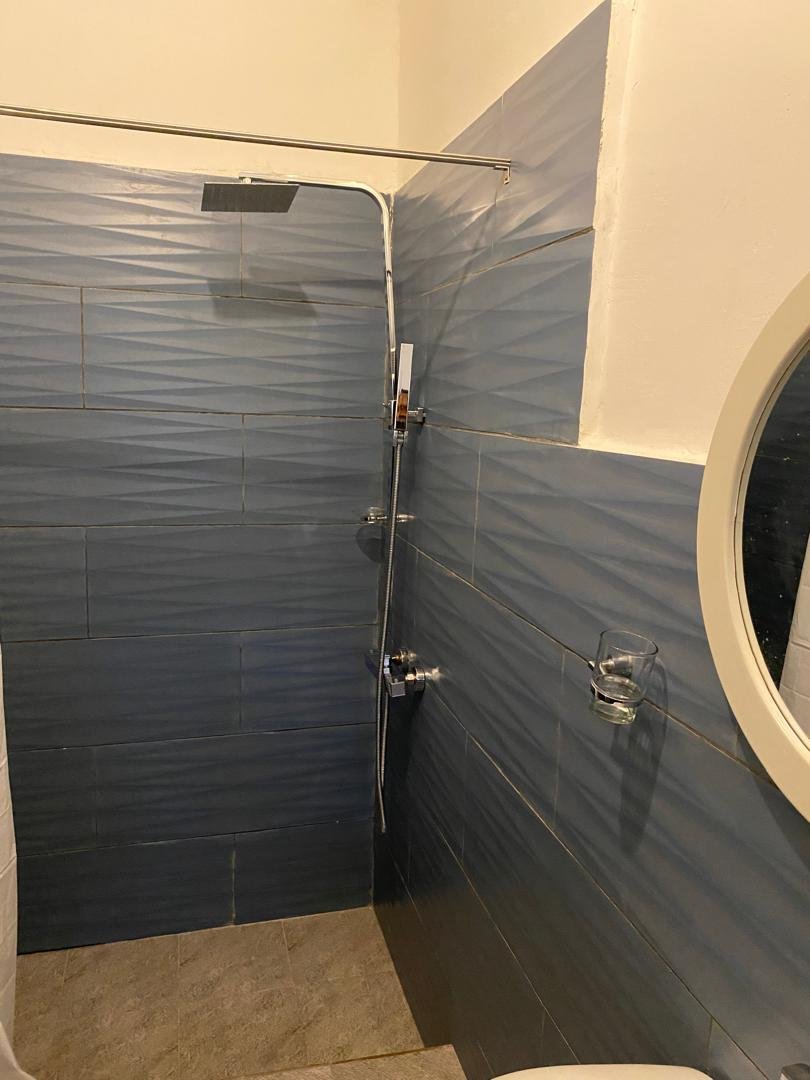En-suite with rain shower and blue feature tiling
