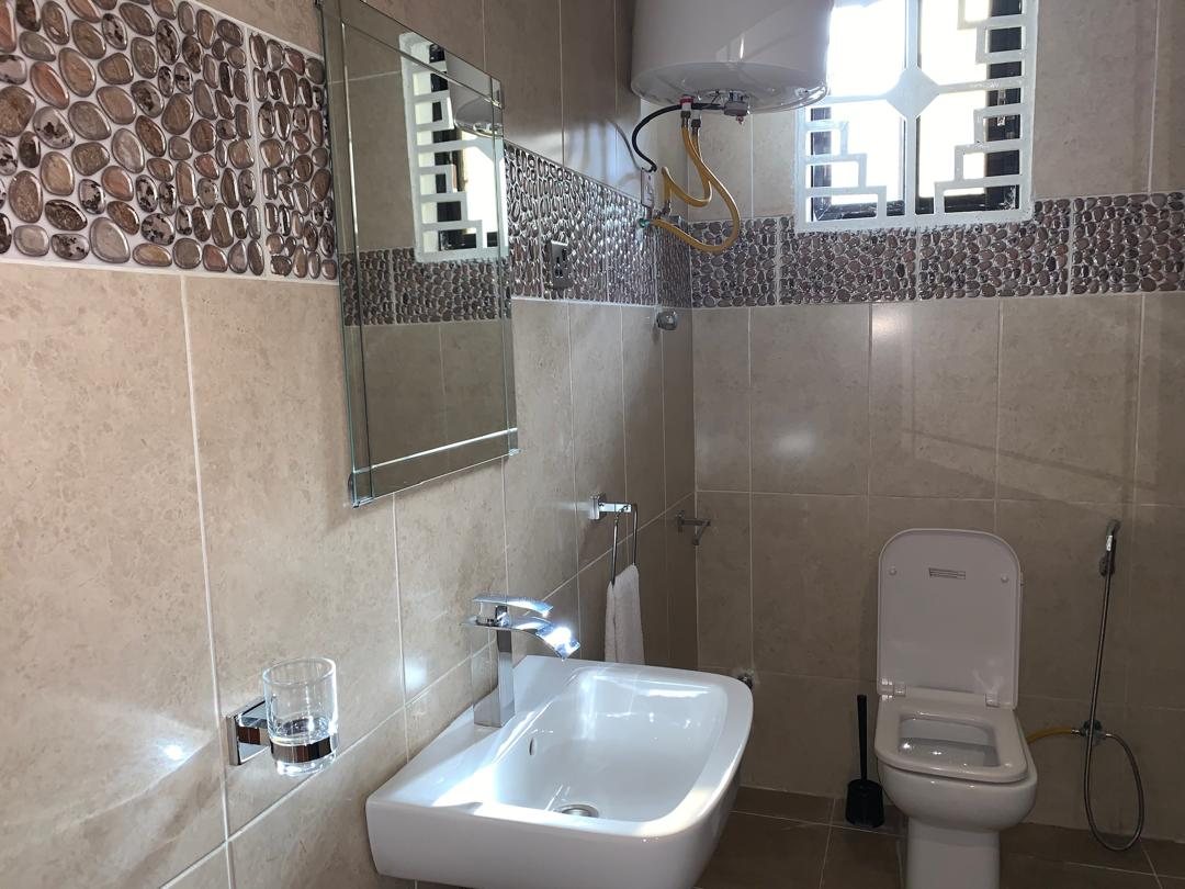 Two-bedroom apartment bathroom with basin, mirror and pebble tiling
