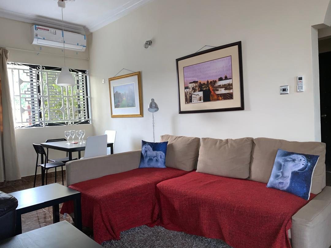 Two-bedroom apartment living room with corner sofa and dining table