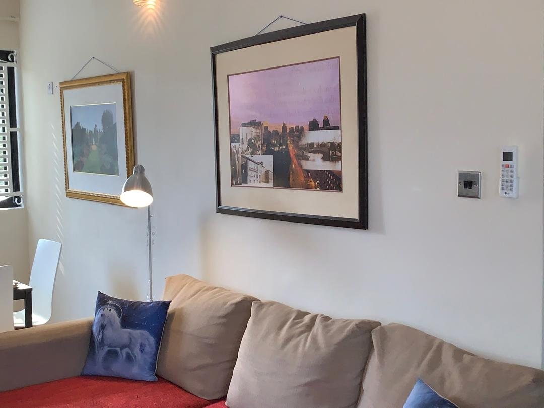 Corner sofa beneath framed prints in the two-bedroom apartment