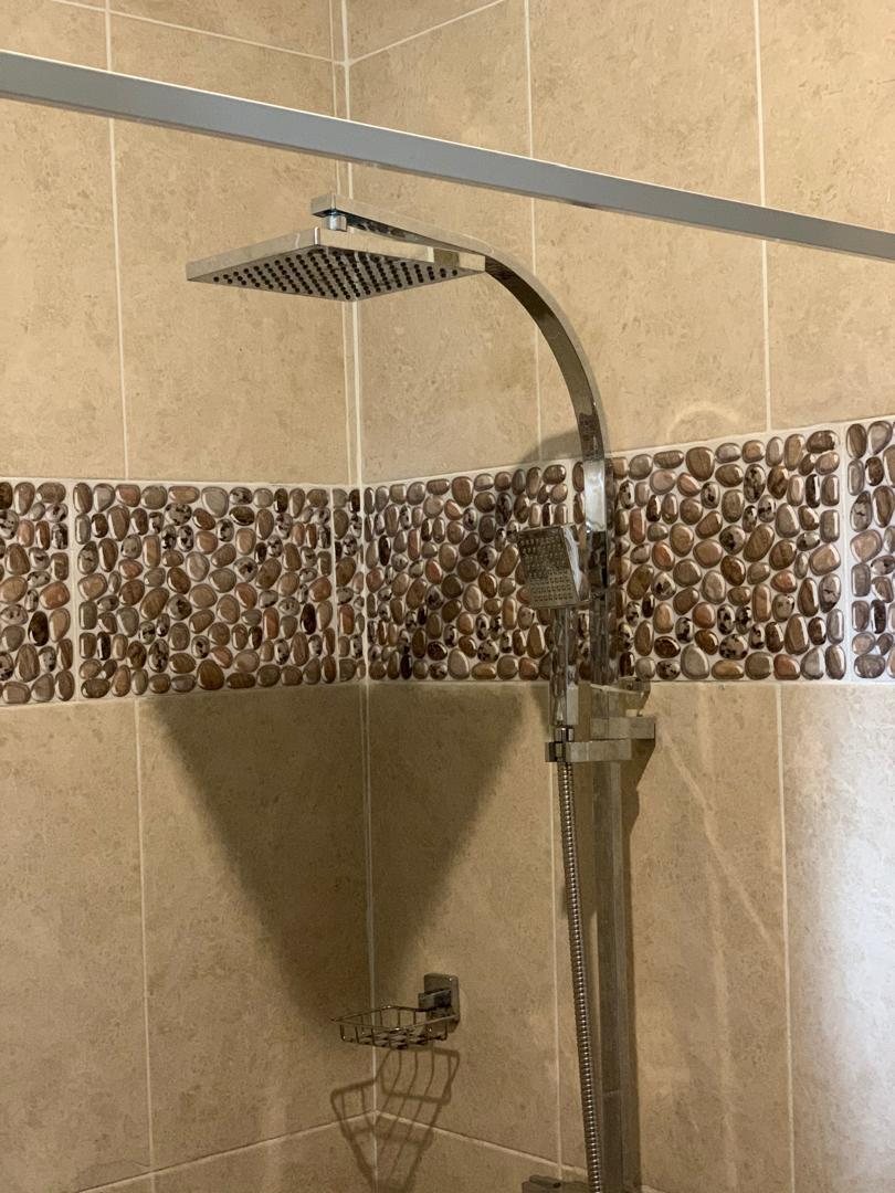 Walk-in shower with rain head and pebble tiling